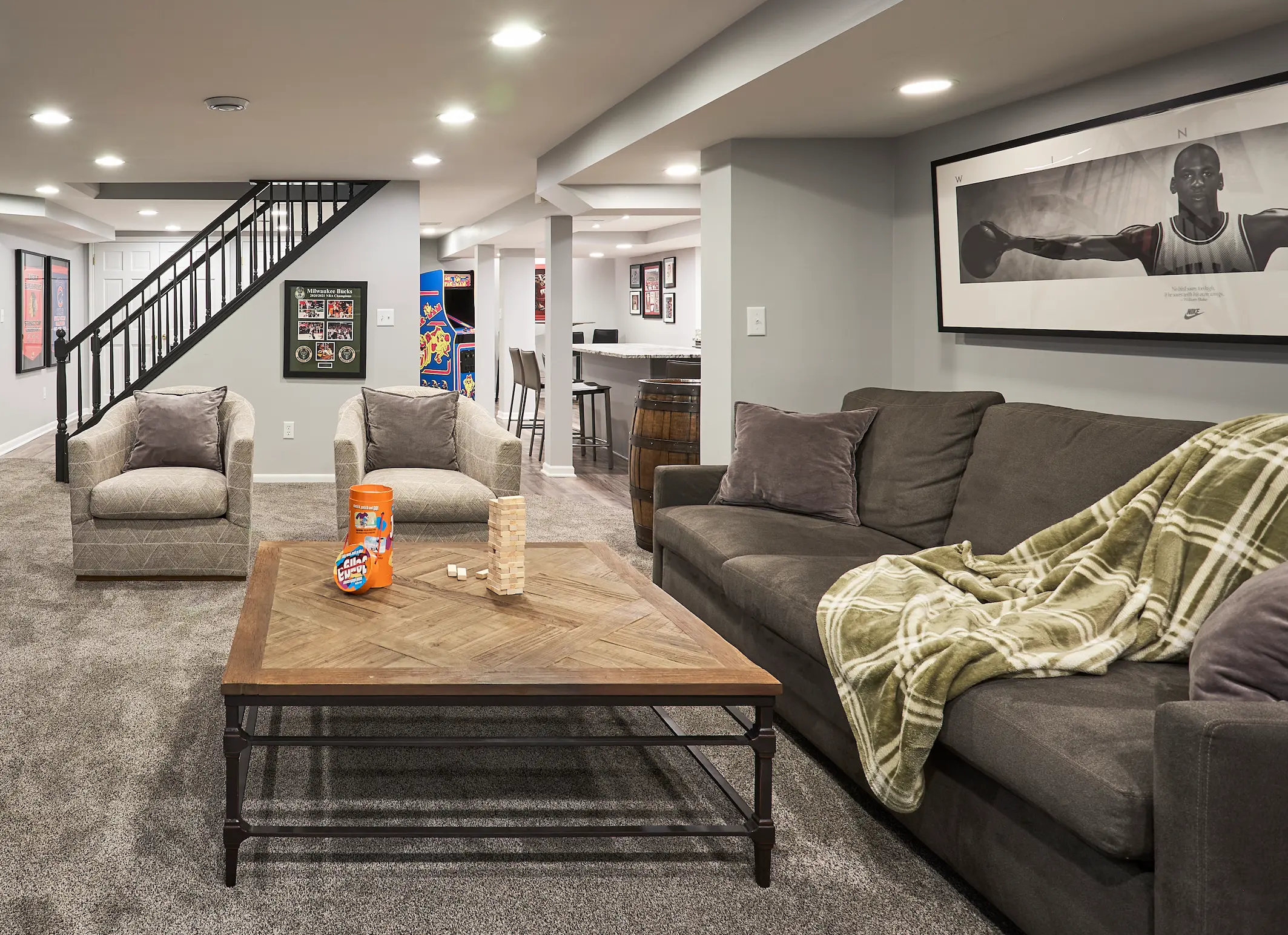Completed lower-level family room with comfortable seating and layered lighting